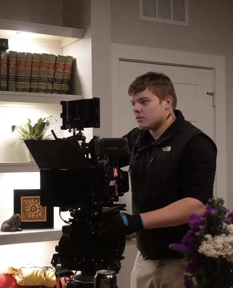 Matthew Nelson operating a cinema camera on an interior set