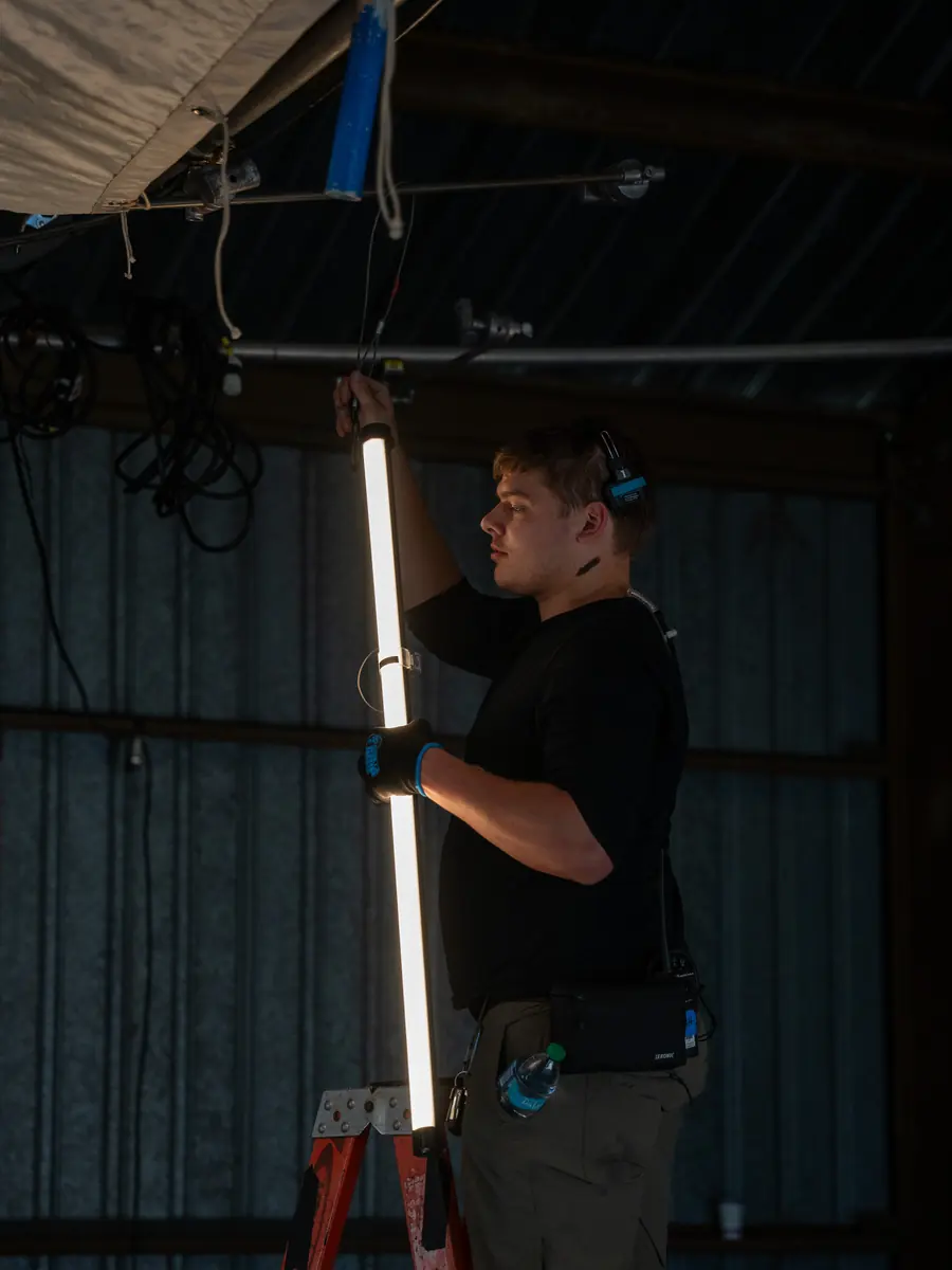 Matthew Nelson rigging a tube light from a ladder